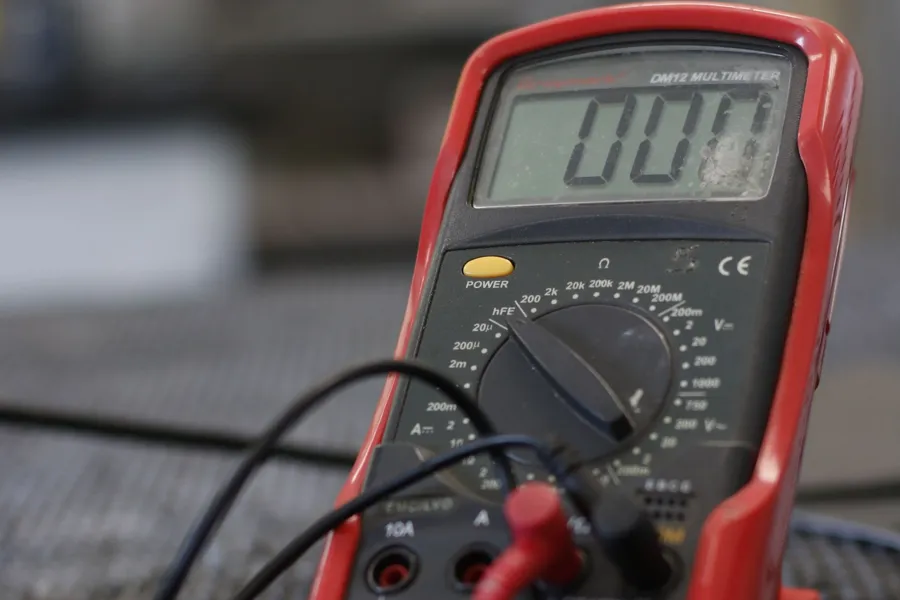 Multimeter neben Kabeln und Stecker (Symbolbild).