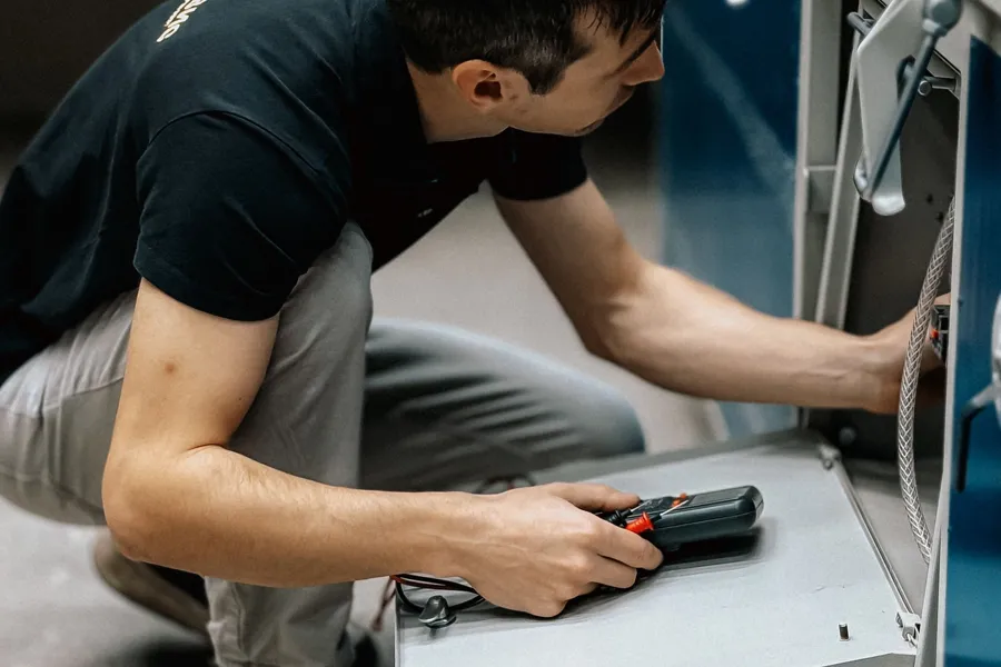 Elektrofachkraft prüft eine Maschine in der Werkstatt (Symbolbild).